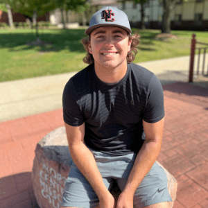 Sport student sitting on the NCMC rock marker