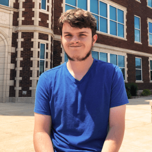 Student on bench in front of Geyer Hall