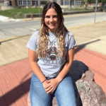 Student sitting on stone marker